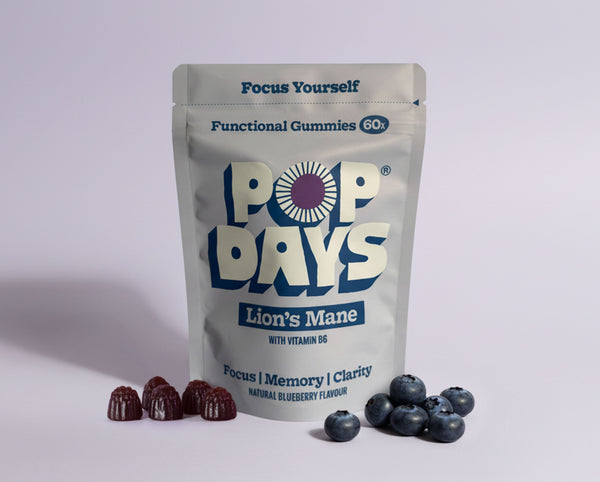 Pop Days lion's mane functional gummies packaging with blueberries on a light grey background