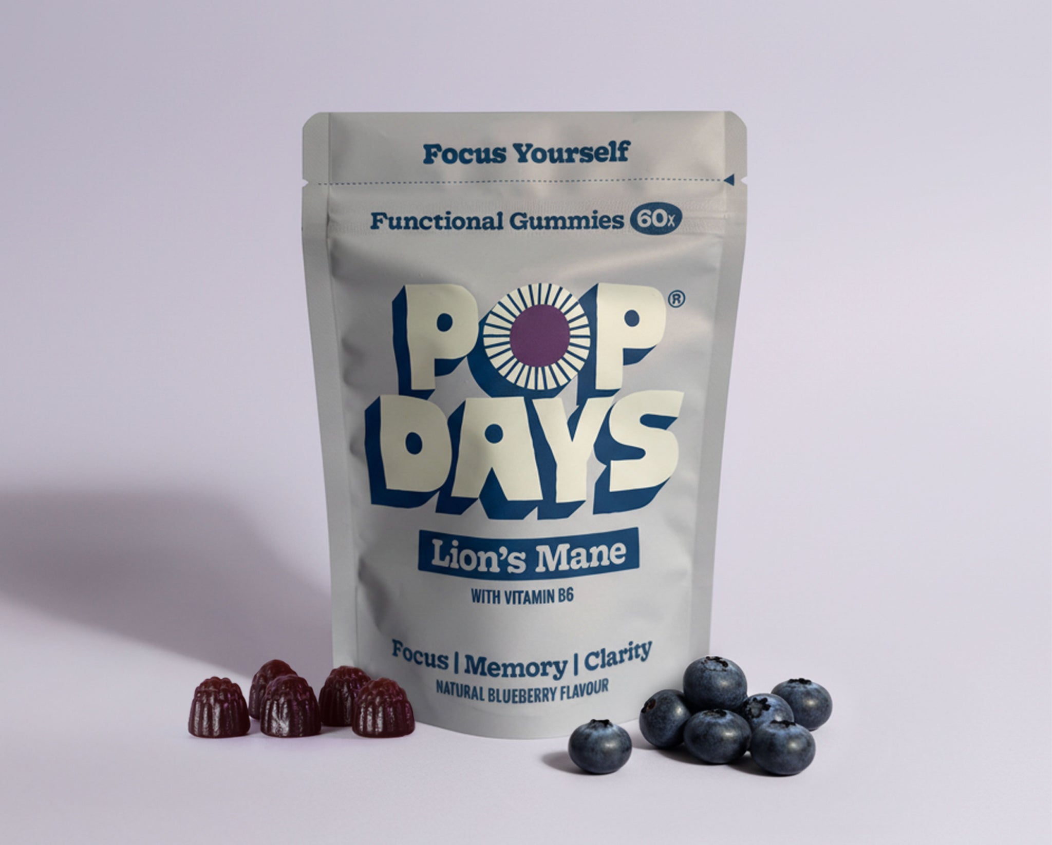 Pop Days lion's mane functional gummies packaging with blueberries on a light grey background